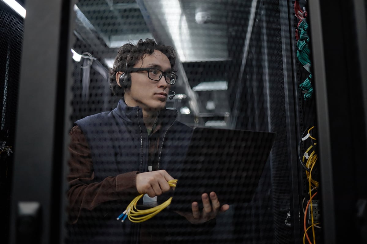 Técnico de IRMANI realizando mantenimiento en servidores con equipo de networking